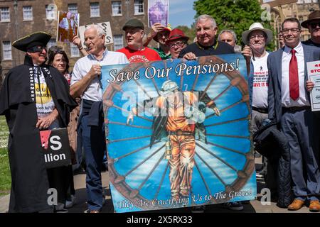 Gli ex minatori e le loro famiglie protestano al di fuori delle camere del Parlamento per le passate ingiustizie nella pensione dei lavoratori della miniera. Nel 1994 è stato firmato un accordo di privatizzazione, il che significa che il governo avrebbe ottenuto la metà di qualsiasi eccedenza di liquidità da un regime pensionistico dei minatori, in cambio della garanzia di un aumento delle pensioni. Il governo ha confermato di aver ricevuto 4,8 miliardi di sterline dal programma negli ultimi 30 anni. Gli attivisti credono che la cifra sia più vicina a 8 miliardi di sterline, e marciarono fino a Downing Street per chiedere il rimborso in eccedenza. Foto Stock