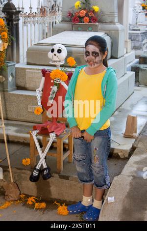 Oaxaca; Messico; Nord America; Day of the Dead Celebrations. Le famiglie scattano foto dei loro figli accanto a un manichino per bambini. Foto Stock