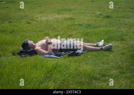 Wimbledon, Londra, Regno Unito. 11 maggio 2024. Un uomo che prende il sole a Wimbledon Common, a sud-ovest di Londra, mentre le temperature raggiungono i 27 °C oggi nel weekend più caldo dell'anno finora. Crediti: amer ghazzal/Alamy Live News Foto Stock