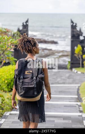 Bali, Indonesia, Vista posteriore di una donna turistica che cammina in direzione del mare Foto Stock