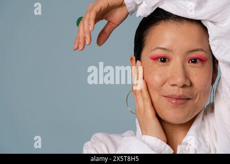 Ritratto di donna adulta che indossa un'ombra rosa Foto Stock