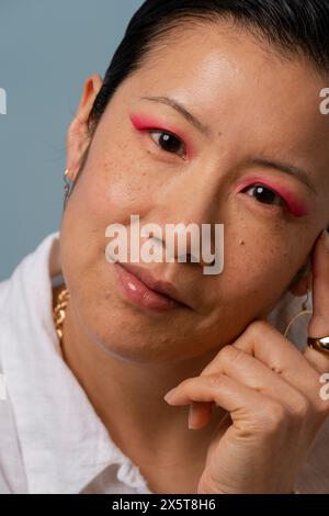 Ritratto di donna adulta che indossa un'ombra rosa Foto Stock