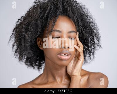 Ritratto in studio di una donna pensiva con gli occhi chiusi Foto Stock