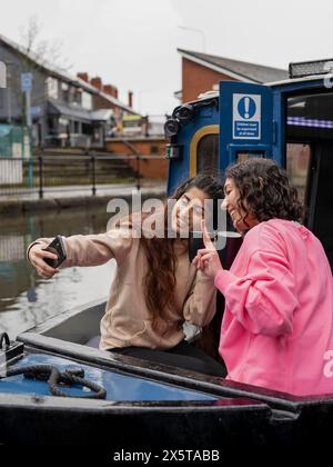 Amici che scattano selfie in barca Foto Stock