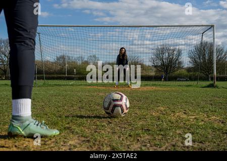 Giocatrici di calcio che praticano il tiro e il salvataggio Foto Stock