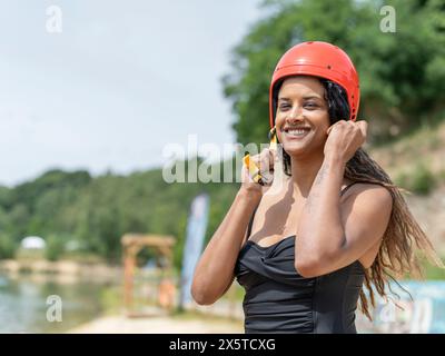 Ritratto di una donna sorridente che indossa un casco sportivo Foto Stock