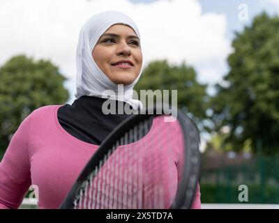 UK, Sutton, Ritratto di donna sorridente con il velo al campo da tennis Foto Stock