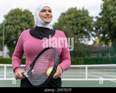 UK, Sutton, Ritratto di donna sorridente con il velo al campo da tennis Foto Stock