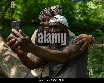 Coppia matura sorridente che si fa selfie durante l'escursione Foto Stock