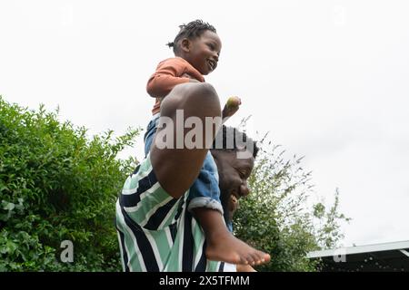 Padre che dà la figlia (2-3) giro in piggyback Foto Stock