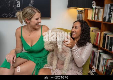 Donne sedute su una poltrona con bedlington terrier Foto Stock