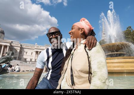 Regno Unito, Londra, felice coppia matura in posa accanto alla fontana in Trafalgar Square Foto Stock