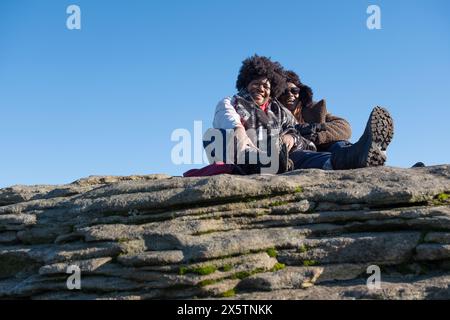 Due donne che si rilassano in cima alla roccia Foto Stock