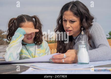 Madre con figlia che legge il menu' nel ristorante all'aperto Foto Stock