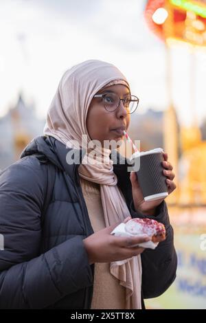 Giovane turista donna in hijab che ha la cioccolata calda Foto Stock