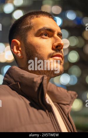 Giovane uomo in piedi all'aperto di notte Foto Stock