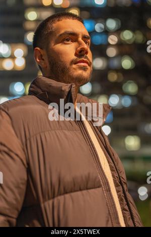 Giovane uomo in piedi all'aperto di notte Foto Stock