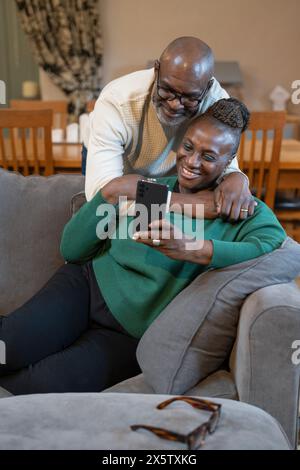 Una coppia di anziani sorridente che fa una videochiamata al telefono Foto Stock