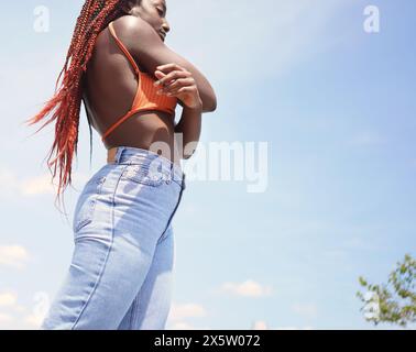 Donna elegante con le braccia incrociate all'aperto Foto Stock