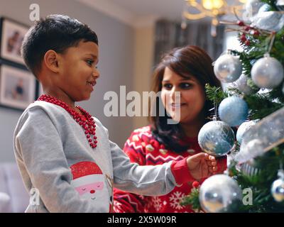 Madre e figlio decorare albero di Natale Foto Stock