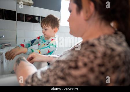 Madre con figlio che lava le mani in bagno Foto Stock