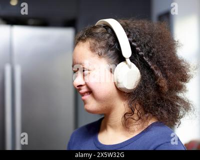 Ragazza con sindrome di Down che indossa le cuffie Foto Stock