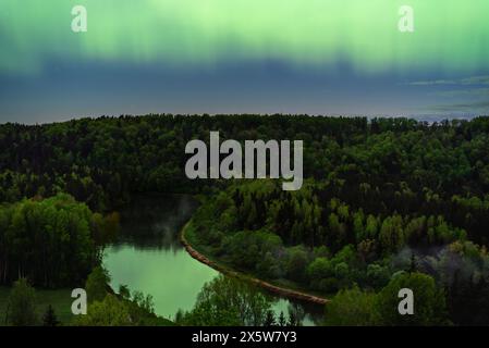 Aurora boreale a nord si illumina sopra il fiume Gauja a Sigulda, in Lettonia, a maggio. Foto Stock