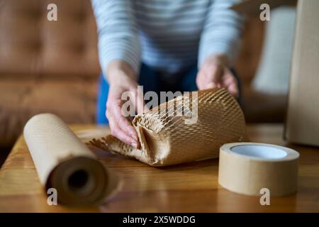 Confezione da donna protetta con carta ecologica o carta da imballaggio a nido d'ape senza plastica Foto Stock