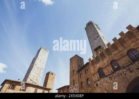 Una splendida vista delle famose torri di San Gimignano in Toscana, in una giornata di sole con cielo blu. Vista dal piano terra nel centro storico. Foto Stock