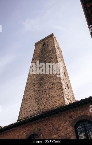 Una splendida vista delle famose torri di San Gimignano in Toscana, in una giornata di sole con cielo blu. Vista dal piano terra nel centro storico. Foto Stock