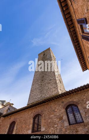 Una splendida vista delle famose torri di San Gimignano in Toscana, in una giornata di sole con cielo blu. Vista dal piano terra nel centro storico. Foto Stock