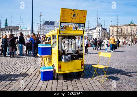 Copenaghen, Danimarca - 6 aprile 2024: Piccolo caffè in tuk-tuk giallo a Kongens Nytorv o Piazza nuova del Re. Foto Stock