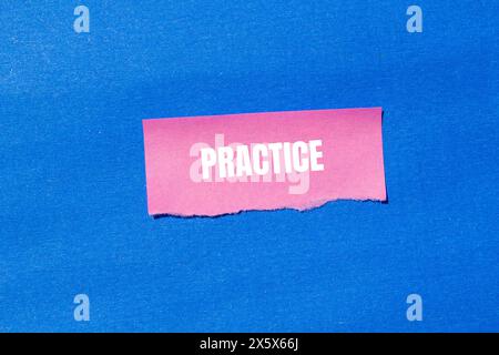 Esercitazione scritta su carta rosa strappata con sfondo blu. Simbolo della pratica concettuale. Copia spazio. Foto Stock