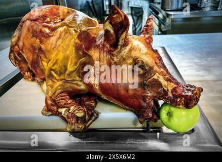 Maiale arrosto con una mela verde in bocca da servire. Foto Stock