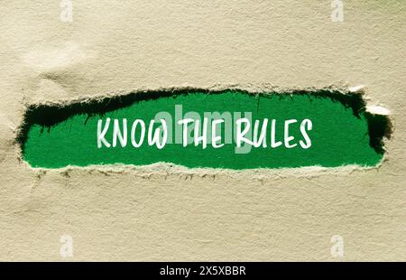 Conoscere le regole scritte su carta strappata con sfondo verde. Il concetto conosce il simbolo delle regole. Copia spazio. Foto Stock