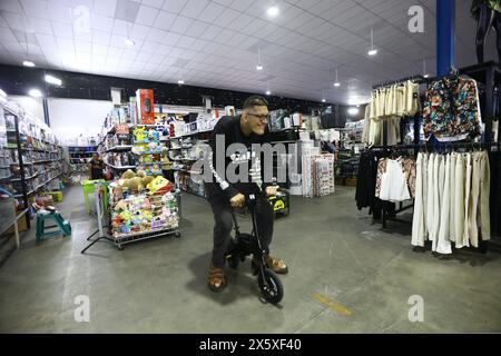 San Diego, Carabobo, Venezuela. 11 maggio 2024. 11 maggio 2024. Jeison Rodriguez, detentore del Guinness World record come l'essere umano con i piedi più grandi del mondo, cavalca una piccola bicicletta durante una visita al negozio di gala nel comune di San Diego, nello stato di Carabobo. Foto: Juan Carlos HernÃndez (immagine di credito: © Juan Carlos Hernandez/ZUMA Press Wire) SOLO PER USO EDITORIALE! Non per USO commerciale! Foto Stock