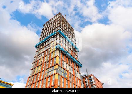 Vista ad angolo basso di una torre residenziale in fase di costruzione in una soleggiata giornata estiva Foto Stock