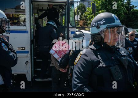 Brooklyn, New York, Stati Uniti. 11 maggio 2024. Un agente della polizia di New York, giusto, fa la guardia mentre un dimostrante viene portato via in manette dopo essere stato arrestato durante una manifestazione al centro Barclays di Brooklyn, New York. I manifestanti ricordavano 76 anni della Nakba durante una giornata nazionale di azione. (Immagine di credito: © Brian Branch Price/ZUMA Press Wire) SOLO PER USO EDITORIALE! Non per USO commerciale! Crediti: ZUMA Press, Inc./Alamy Live News Foto Stock