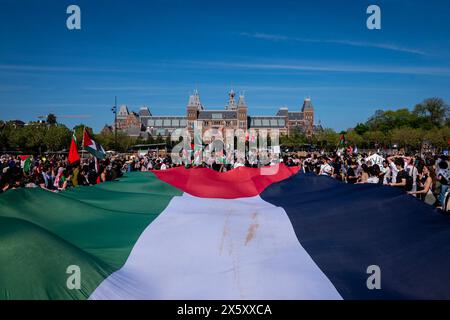 11 maggio 2024, Amsterdam, Olanda settentrionale, Paesi Bassi: Migliaia di manifestanti si riuniscono intorno a una grande bandiera palestinese di fronte al Rijksmuseum di Amsterdam. L'11 maggio 2024, diverse migliaia di manifestanti filo-palestinesi si sono riuniti in Piazza Dam ad Amsterdam. Da Piazza Dam, i manifestanti marciarono fino a Museumplein, Amsterdam, per ulteriori discorsi. L'appello di questa manifestazione richiese la fine della Nakba in Palestina, l'occupazione israeliana e il sostegno del governo olandese al governo israeliano. Crediti: ZUMA Press, Inc./Alamy Live News Foto Stock