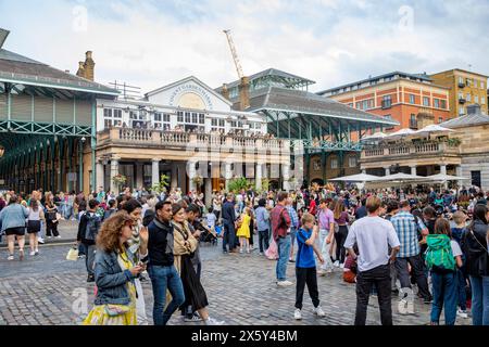 Covent Garden piazza Londra , i giovani si mescolano sulla piazza acciottolata accanto al mercato di Covery Garden e al pub Punch & Judy, Inghilterra, Regno Unito, 2023 Foto Stock