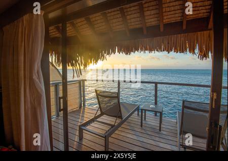 Vista del tramonto dalla terrazza di un bungalow su palafitte, Manava Beach Resort, Moorea, Isole della società, Polinesia francese Foto Stock