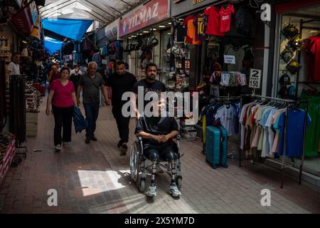 Onur cammina con suo fratello Mahsun Kaba nello storico bazar coperto di Hatay. Onur Kaba è un giovane di 22 anni di Hatay, una città più colpita dai terremoti di magnitudo 7,7 e 7,6 che hanno colpito Kahramanmara? Il 6 febbraio 2023. Onur è stato catturato in casa sua ed è rimasto intrappolato sotto le macerie per 87 ore. Dopo essere stato salvato, Onur è stato portato per la prima volta in un ospedale vicino, dove le sue gambe sono state curate per 12 giorni con vari trattamenti per prevenire l'amputazione. Alla fine, ha perso entrambe le gambe e continua la sua vita come amputato. Onur, che vive ancora ad Hatay, disse: "Ho passato molto d Foto Stock