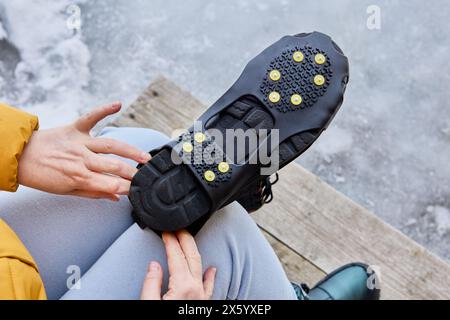 Soprascarpe resistenti con bottone in acciaio per la presa a terra, perni antiscivolo che possono offrire trazione su ghiaccio e neve per le calzature. Foto Stock