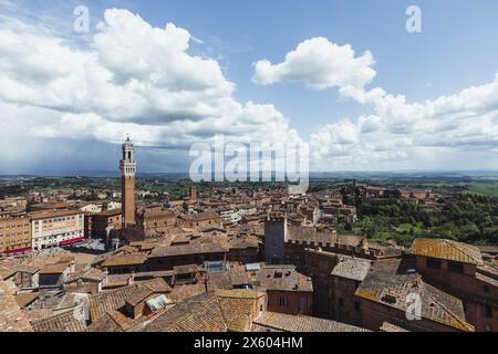 La famosa Torre del Mangia vista dal punto panoramico Panorama dal Facciatone nella città vecchia di Siena, in Toscana, in una giornata di sole con cielo blu. Foto Stock