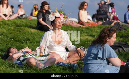 Persone tra cui Jazz Smith fron Dublin (centro) meditano durante il Bealtaine Fire Festival sulla collina di Uisneach nella contea di Westmeath. Data foto: Sabato 11 maggio 2024. Foto Stock