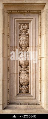 Pannello intagliato in stile art nouveau sull'esterno di un edificio. Pannello decorativo ornato con foglie e fiori. Design tradizionale in pietra calcarea. Foto Stock