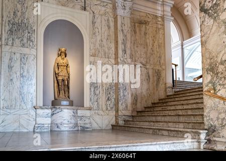 Londra, Regno Unito - 17 aprile 2022: Antica statua di un re esposta nella grande scalinata di marmo del Victoria and Albert Museum di Londra. Foto Stock
