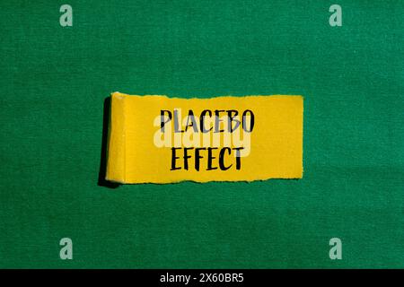 Parole con effetto placebo scritte su carta gialla strappata con sfondo verde. Simbolo concettuale dell'effetto placebo. Copia spazio. Foto Stock