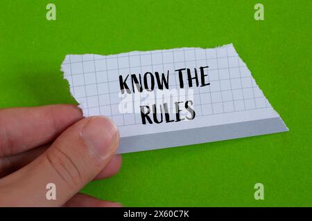 Conoscere le regole scritte su carta strappata con sfondo verde. Il concetto conosce il simbolo delle regole. Copia spazio. Foto Stock