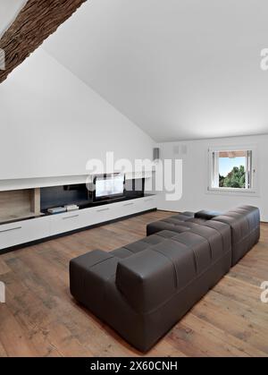 moderno soggiorno interno in primo piano il divano in pelle marrone il pavimento è in legno Foto Stock